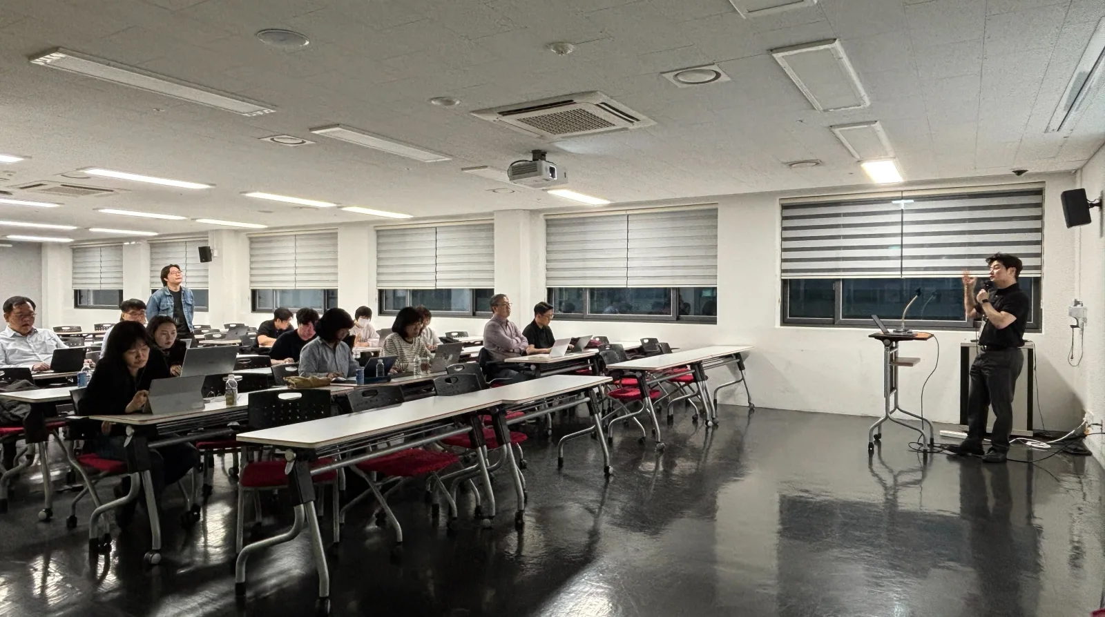 오프라인 강의실에서 강사가 수강생들 앞에서 전용 HTS 사용을 안내하는 모습